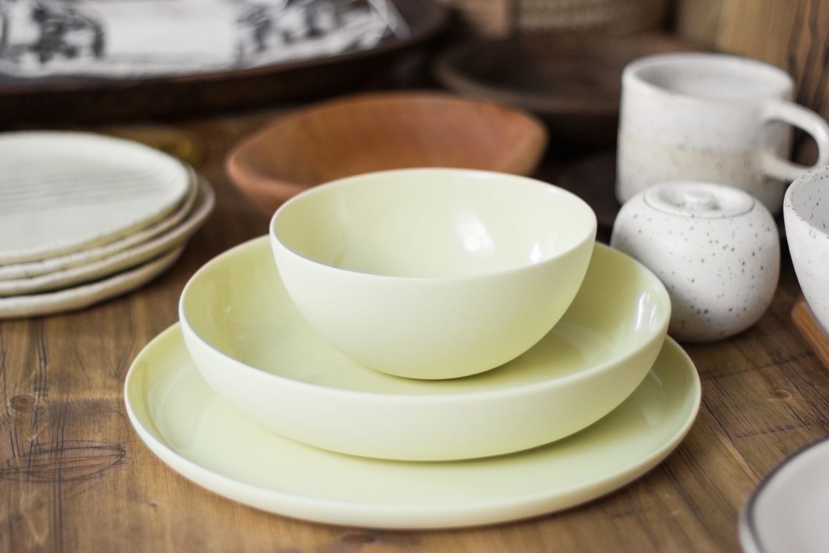Illustrative collection of neutral ceramic crockery on a wooden table